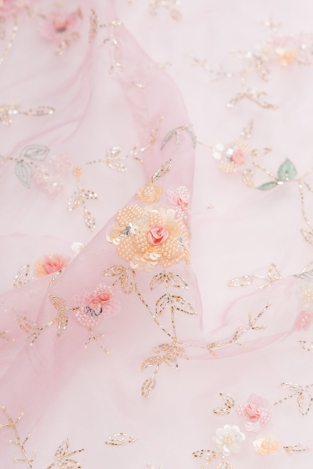 Close up of Pure Silk Pink Organza Saree with Embroidered on the body and Sequin Border.  displaying folds