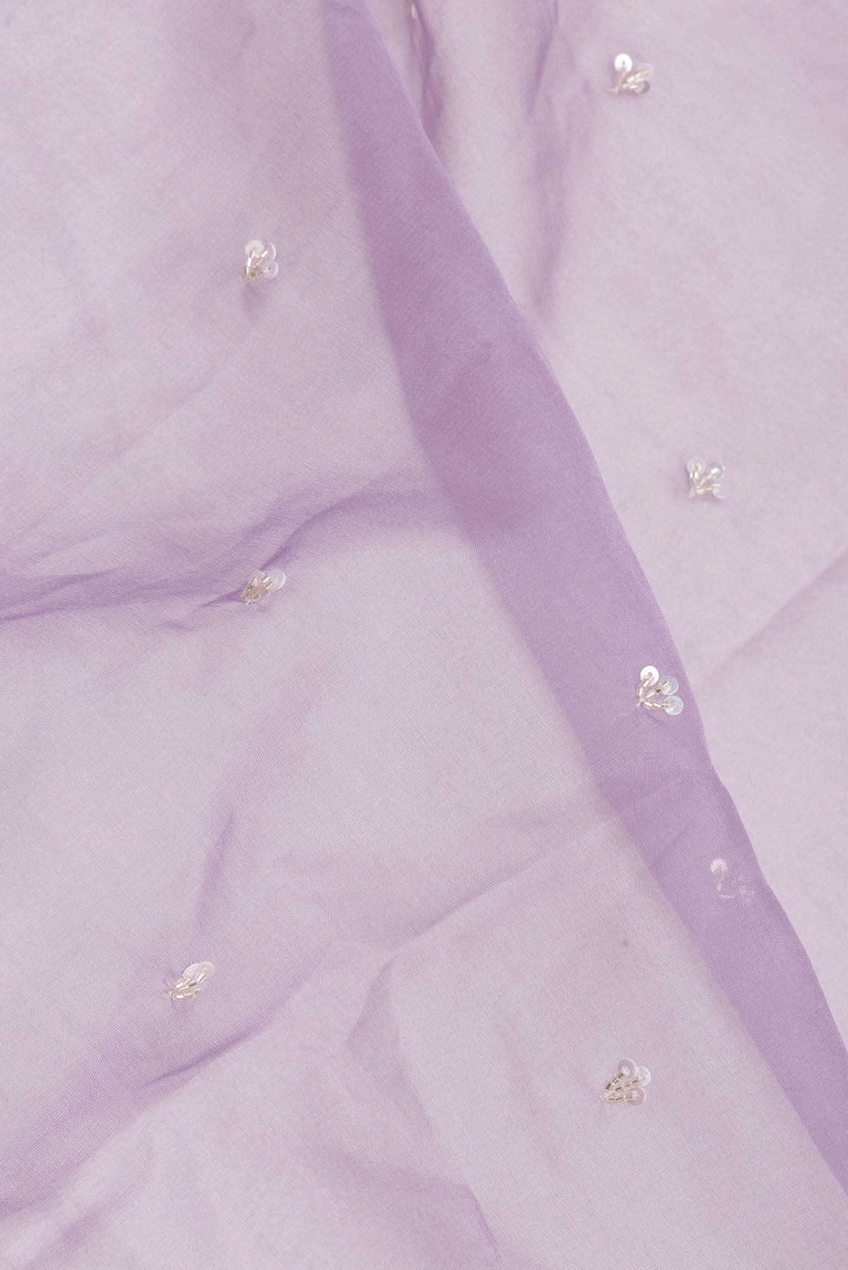 Close up of Pure Silk Lavender Dual Tone Organza Saree with Embroidery on the body and Sequin Border.  displaying folds