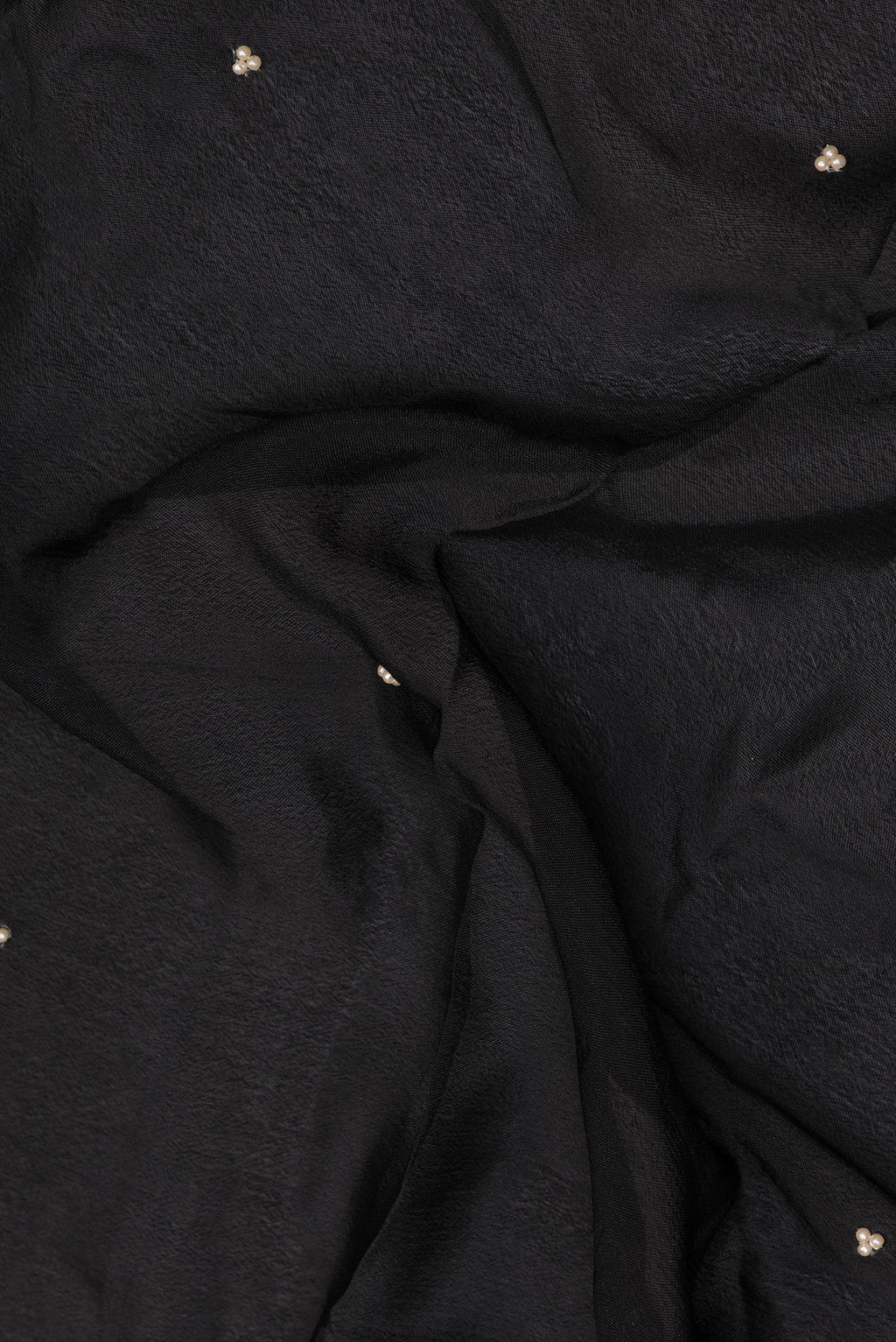 Close up of Black Crepe Saree with Embroidered on the body and Embroidered Border.  displaying folds