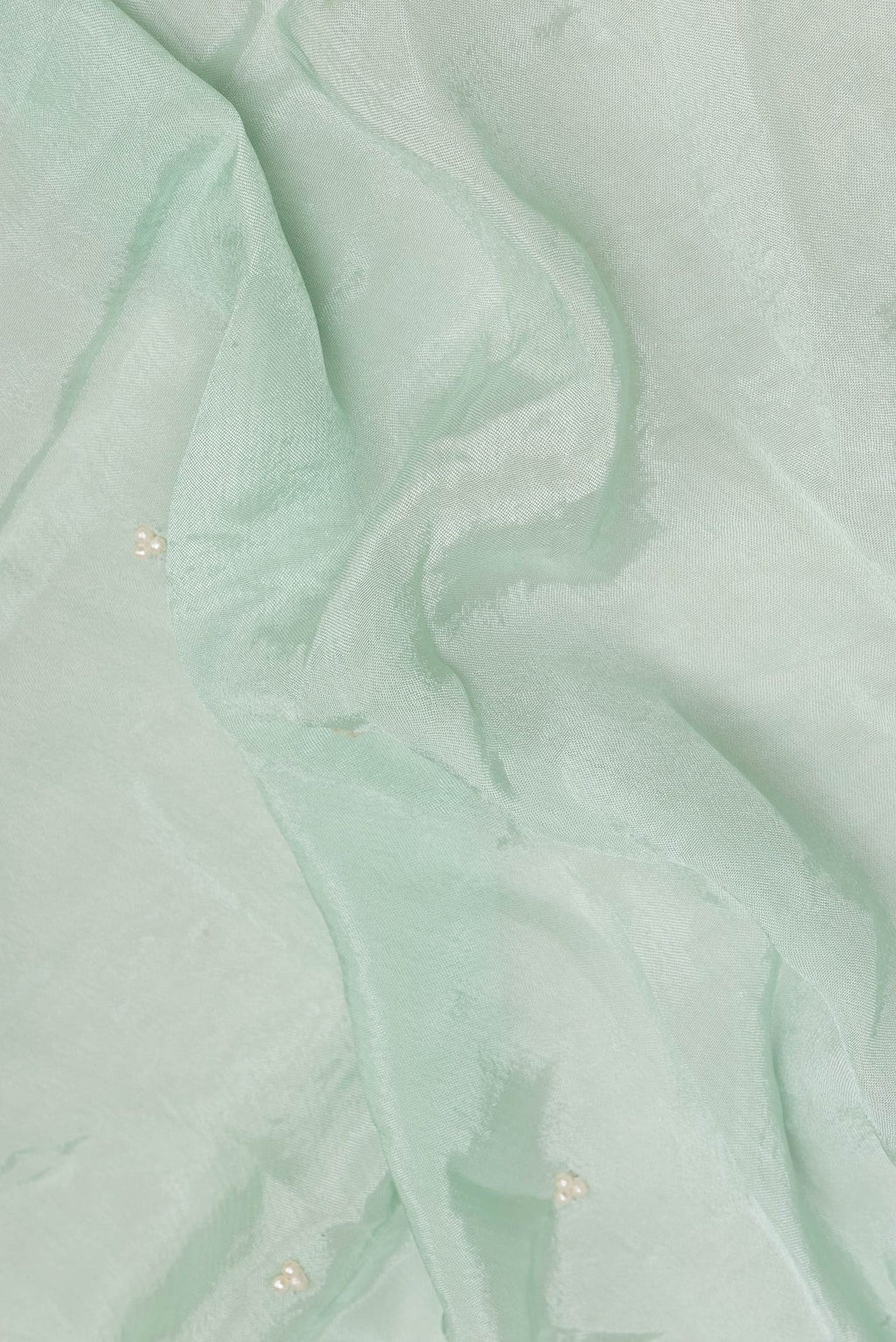 Close up of Mint Green Crepe Saree with Embroidered on the body and Sequin Border.  displaying folds
