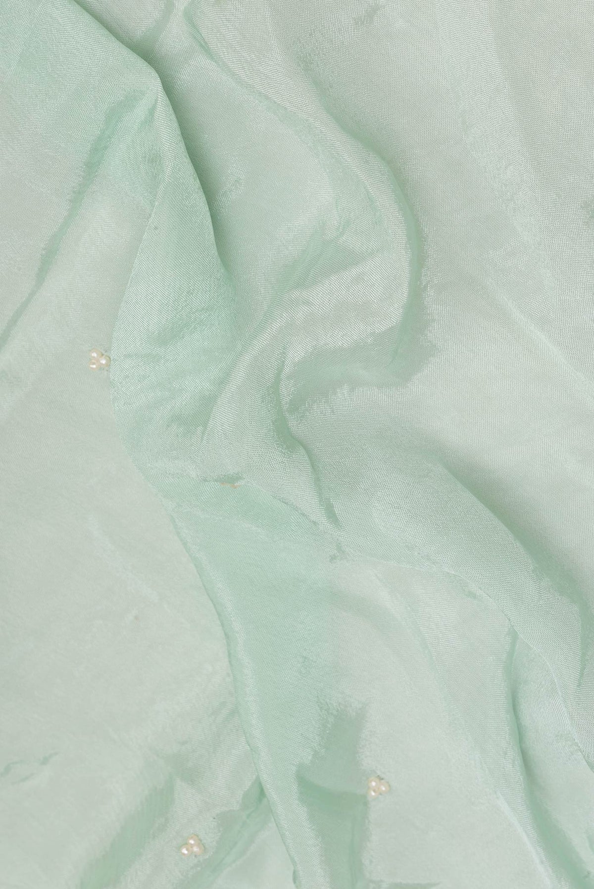 Close up of Mint Green Crepe Saree with Embroidered on the body and Sequin Border.  displaying folds