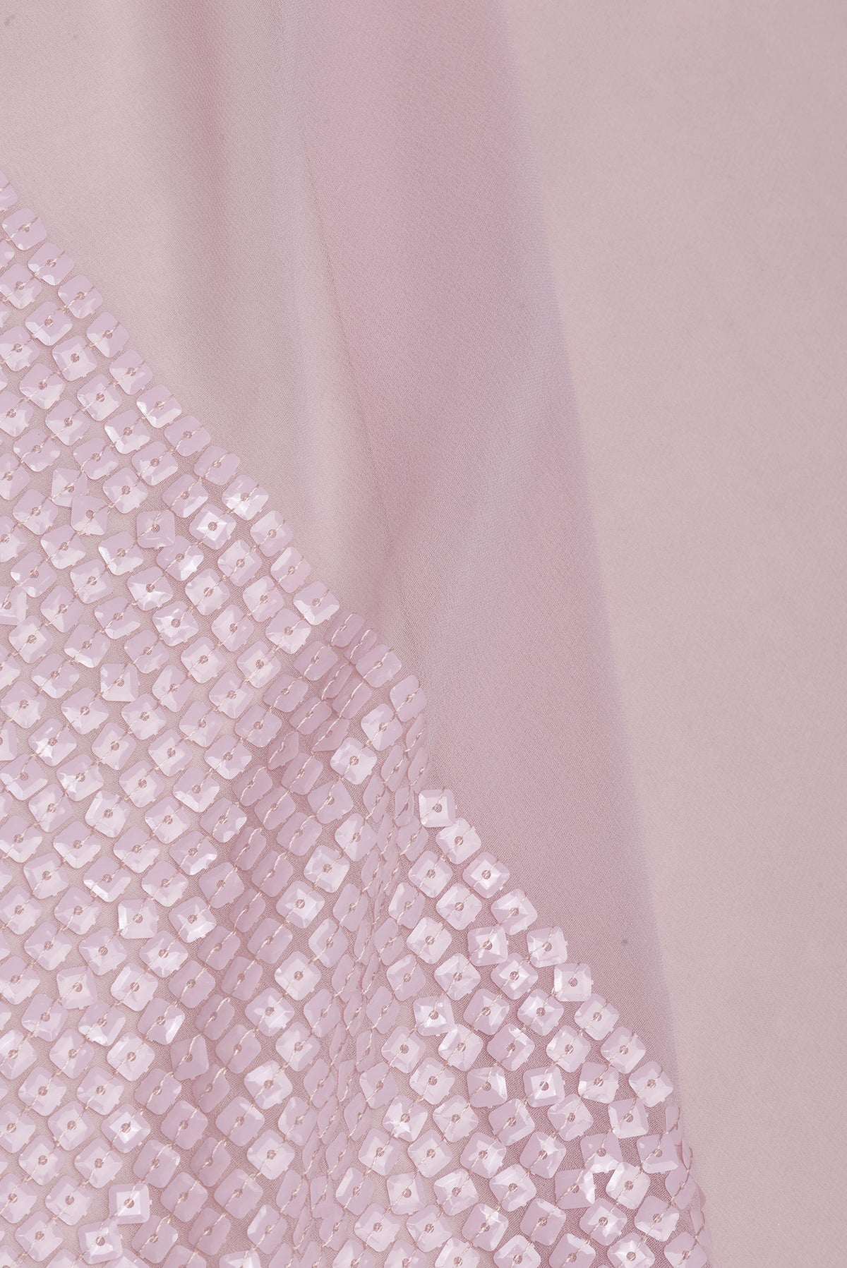 Close up of Rose Gold Georgette Saree with Embroidered on the body and Sequin Border.  displaying folds