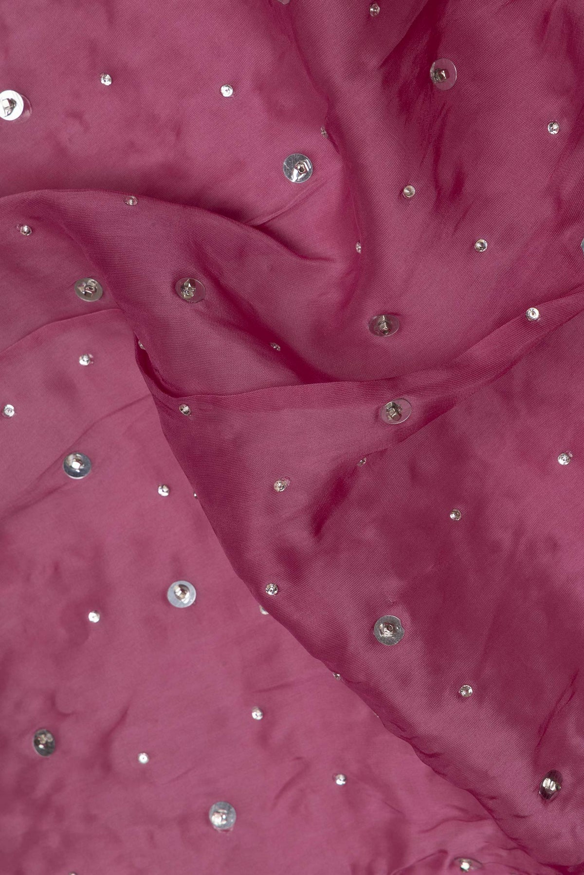 Close up of Magenta Organza Saree with Embroidered on the body and Sequin Border.  displaying folds