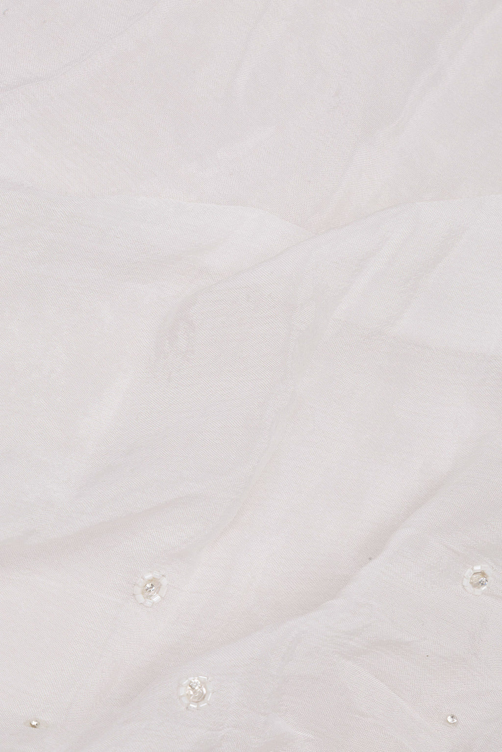 Close up of White Organza Saree with Embroidered on the body and Sequin Border.  displaying folds