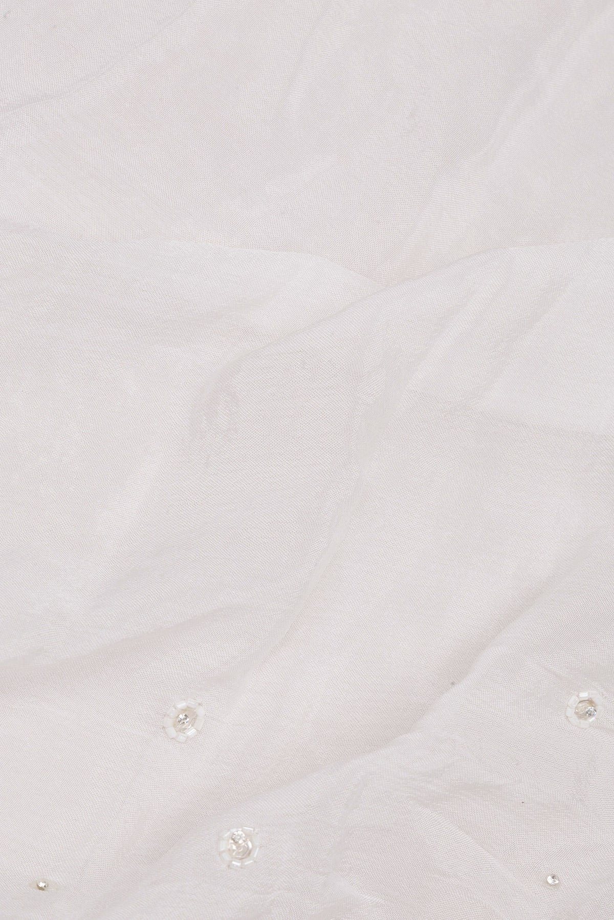 Close up of White Organza Saree with Embroidered on the body and Sequin Border.  displaying folds