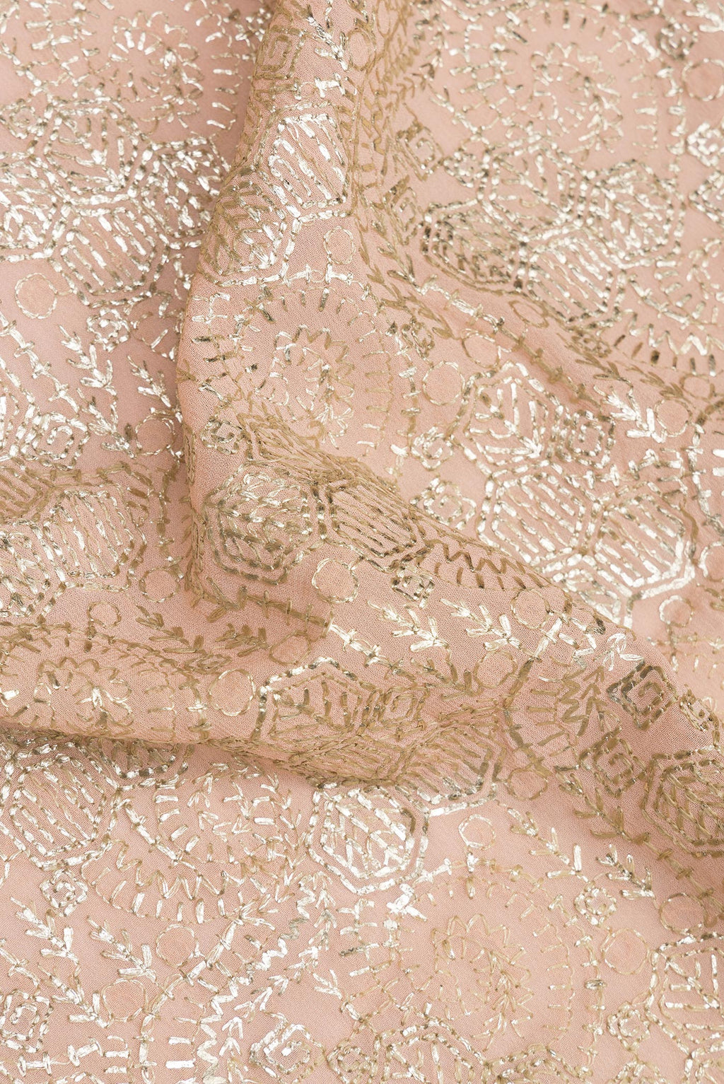 Close up of Peach Dual Tone Georgette Saree with Embroidered on the body and Sequin Border.  displaying folds