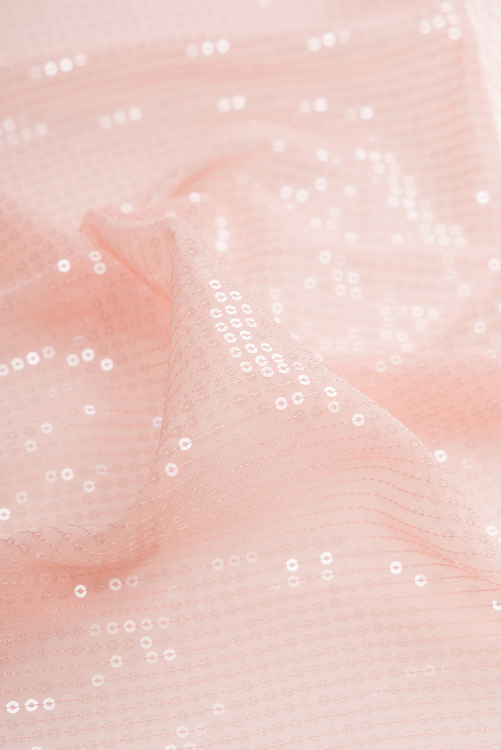 Close up of Golden Peach Georgette Saree with Embroidered on the body and Sequin Border.  displaying folds