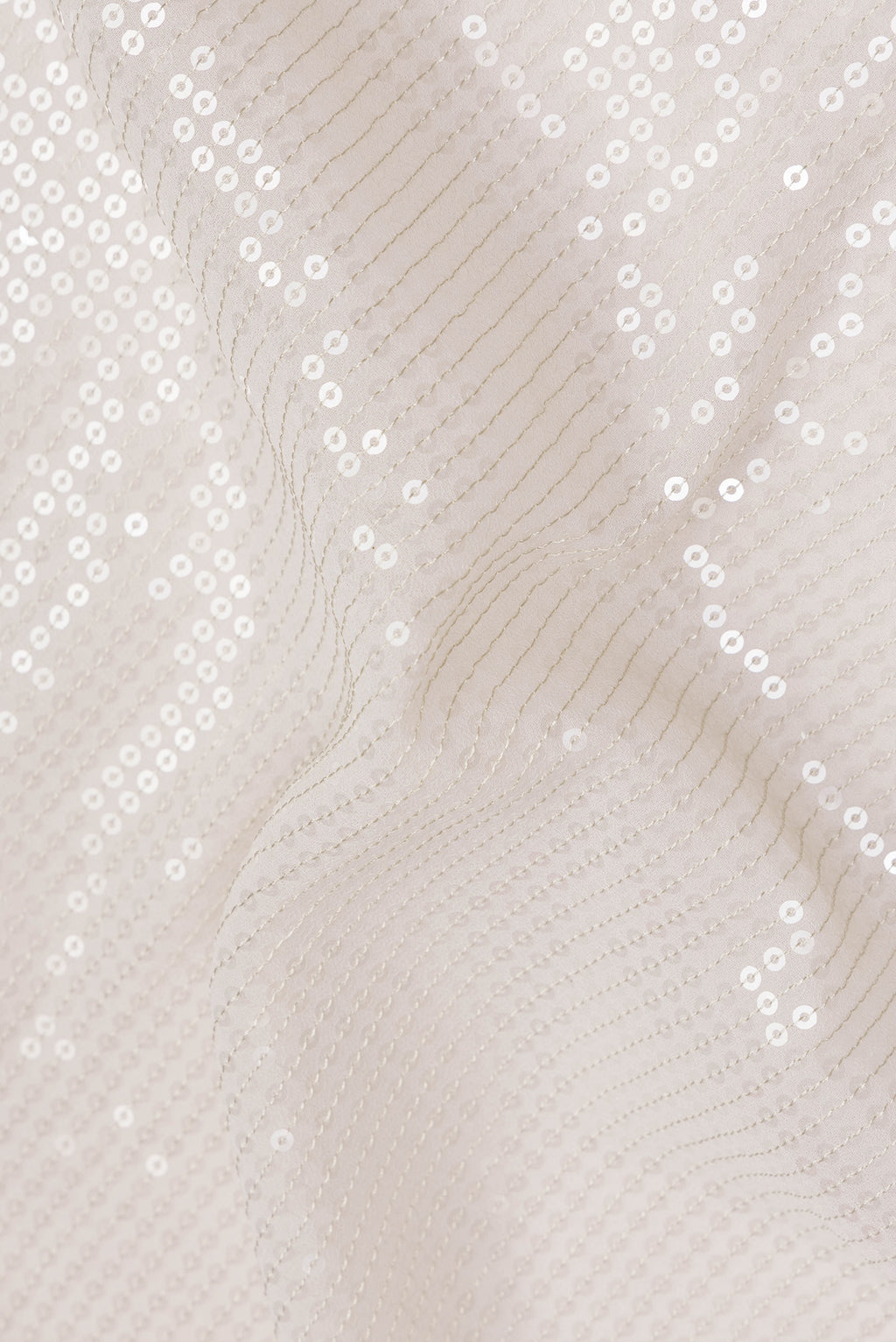 Close up of Cream Georgette Saree with Embroidered on the body and Sequin Border.  displaying folds