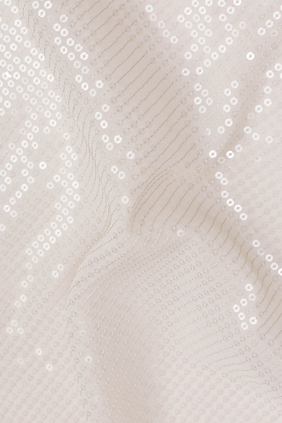Close up of Cream Georgette Saree with Embroidered on the body and Sequin Border.  displaying folds