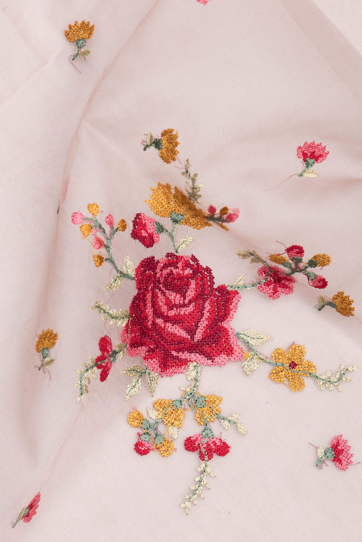 Close up of Rose Gold Organza Saree with Embroidered on the body and Embroidered Border.  displaying folds