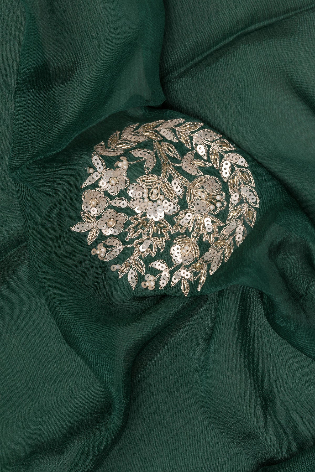 Close up of Bottle Green Crepe Saree with Embroidered on the body and Sequin Border.  displaying folds