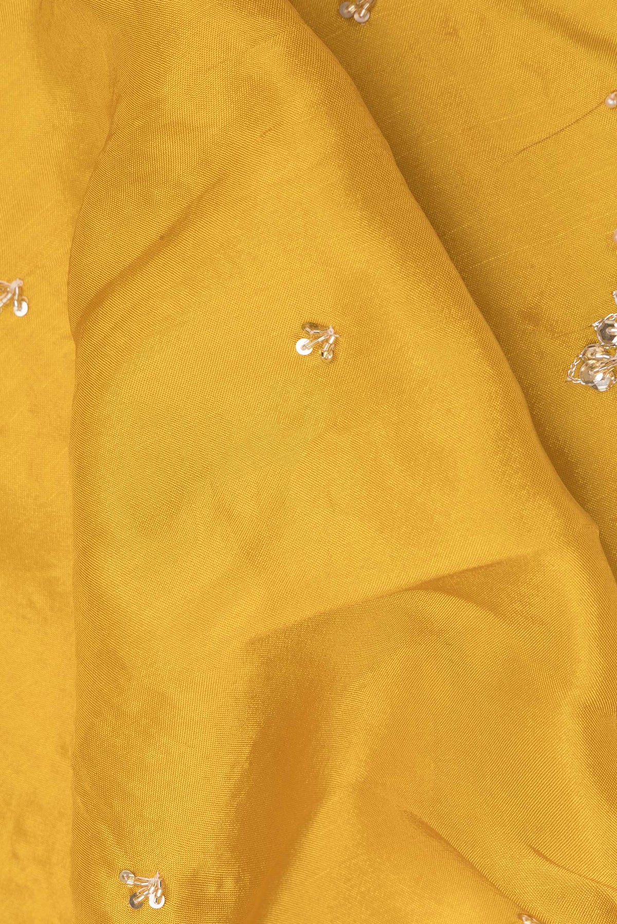 Close up of Yellow Crepe Saree with Embroidered on the body and Embroidered Border.  displaying folds