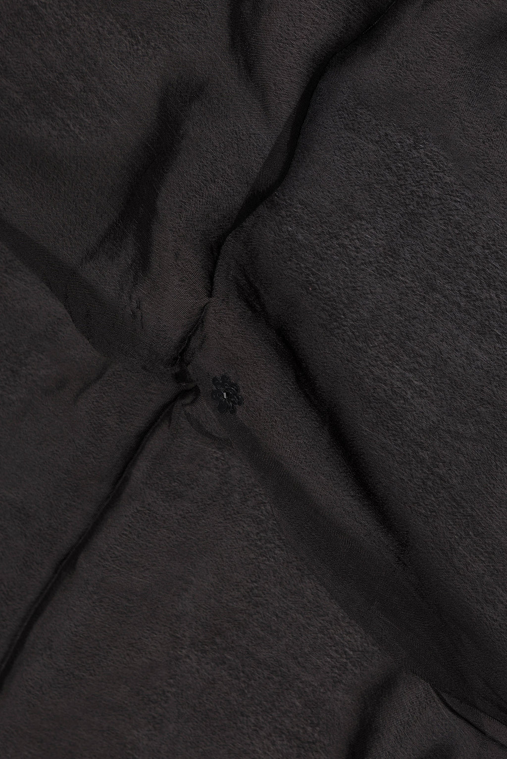 Close up of Black Crepe Saree with Embroidered on the body and Sequin Border.  displaying folds