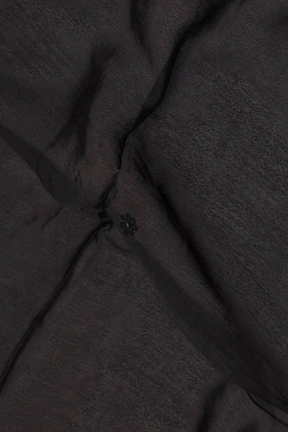 Close up of Black Crepe Saree with Embroidered on the body and Sequin Border.  displaying folds