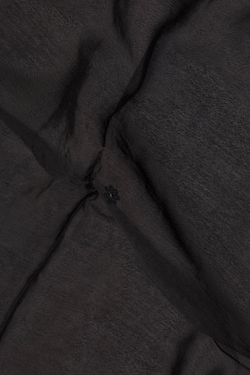 Close up of Black Crepe Saree with Embroidered on the body and Sequin Border.  displaying folds