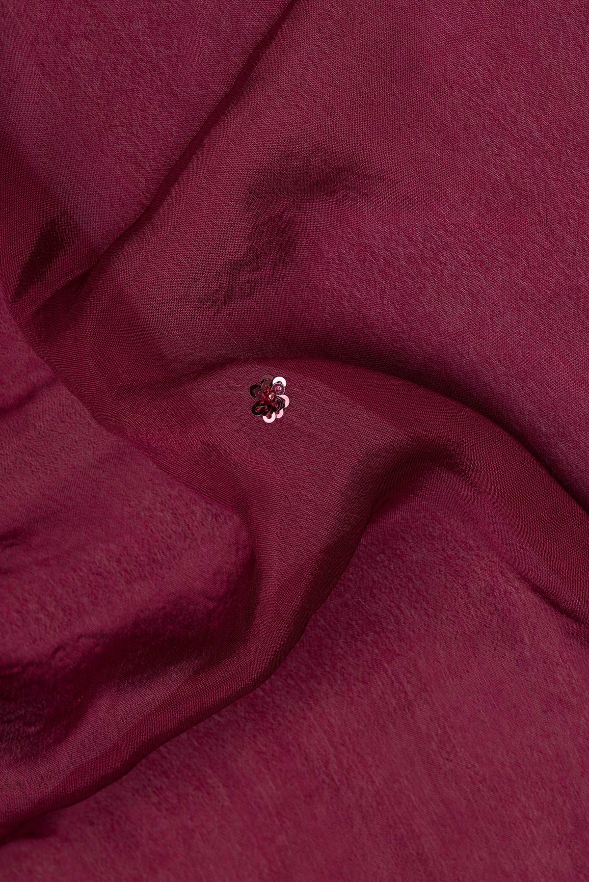 Close up of Maroon Crepe Saree with Embroidered on the body and Embroidered Border.  displaying folds