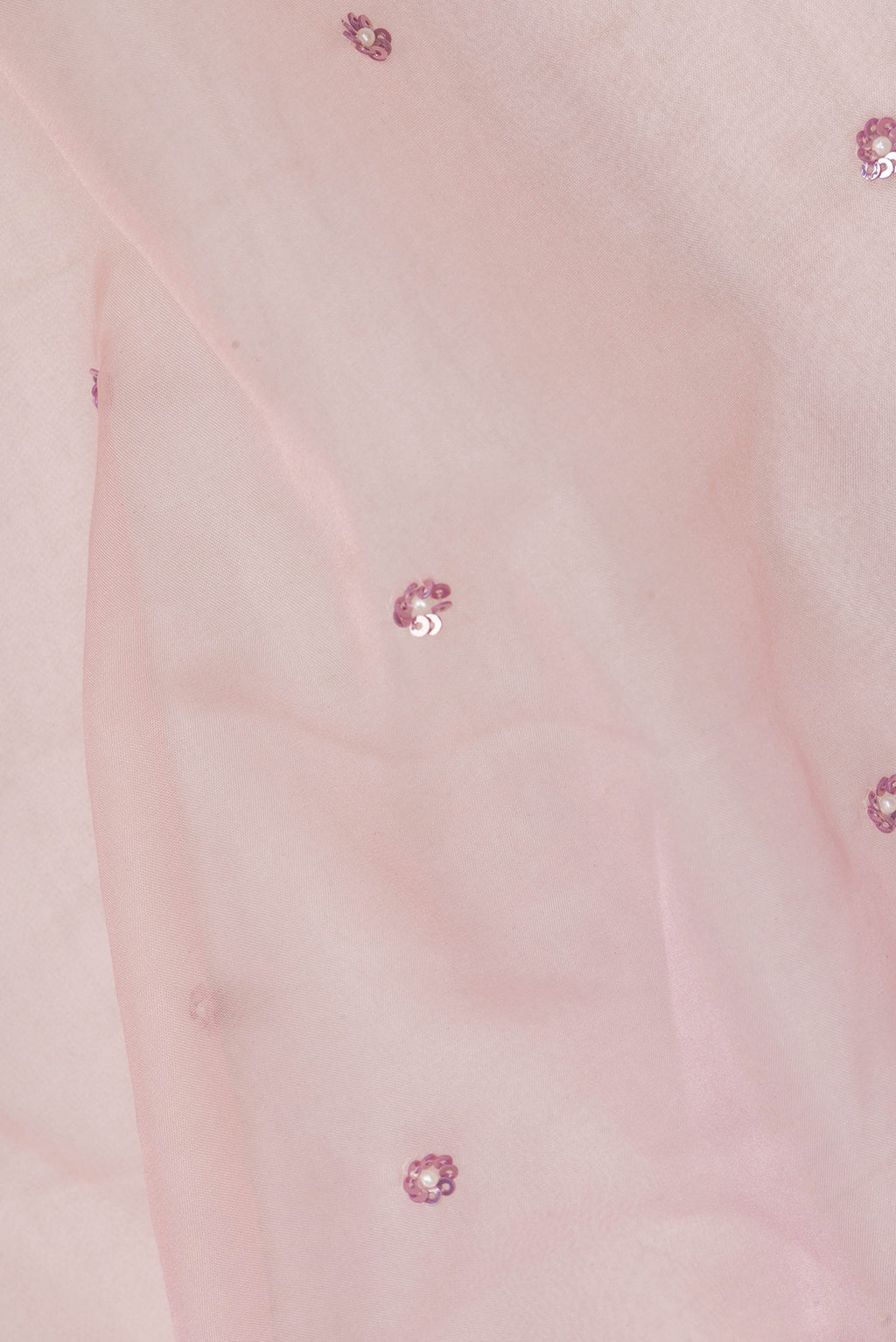 Close up of Golden Peach Organza Saree with Embroidered on the body and Sequin Border.  displaying folds