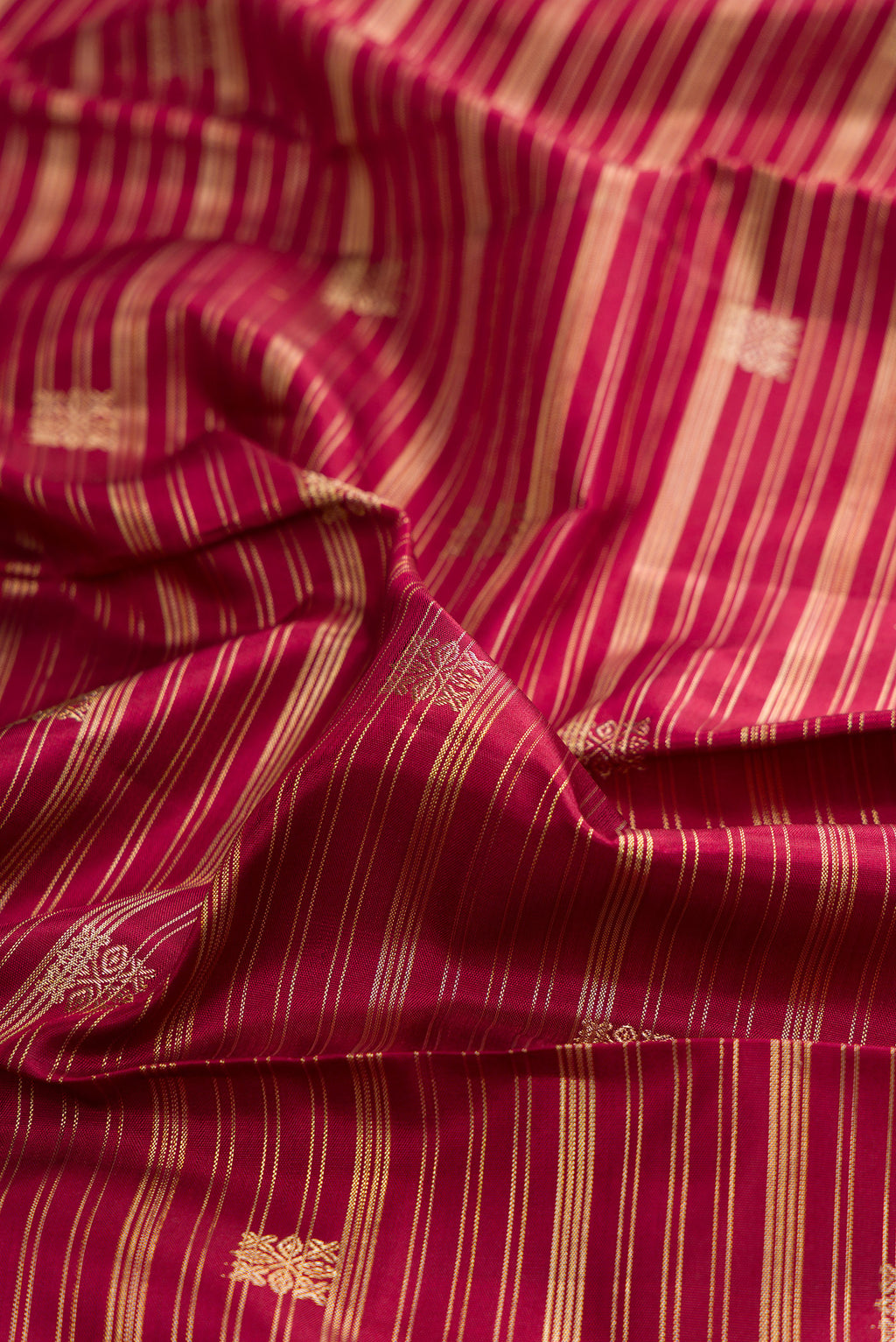 Close up of Pure Silk Maroon Kanchipuram Saree with Stripes on the body and Zari Border.  displaying folds