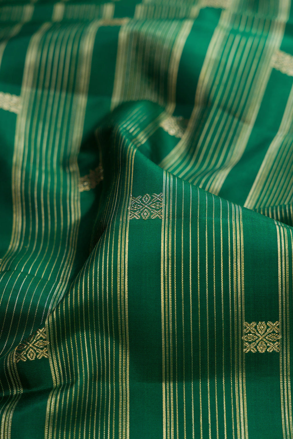 Close up of Bottle Green Kanchipuram Silk Saree with Stripes on the body and Fancy Border.  displaying folds