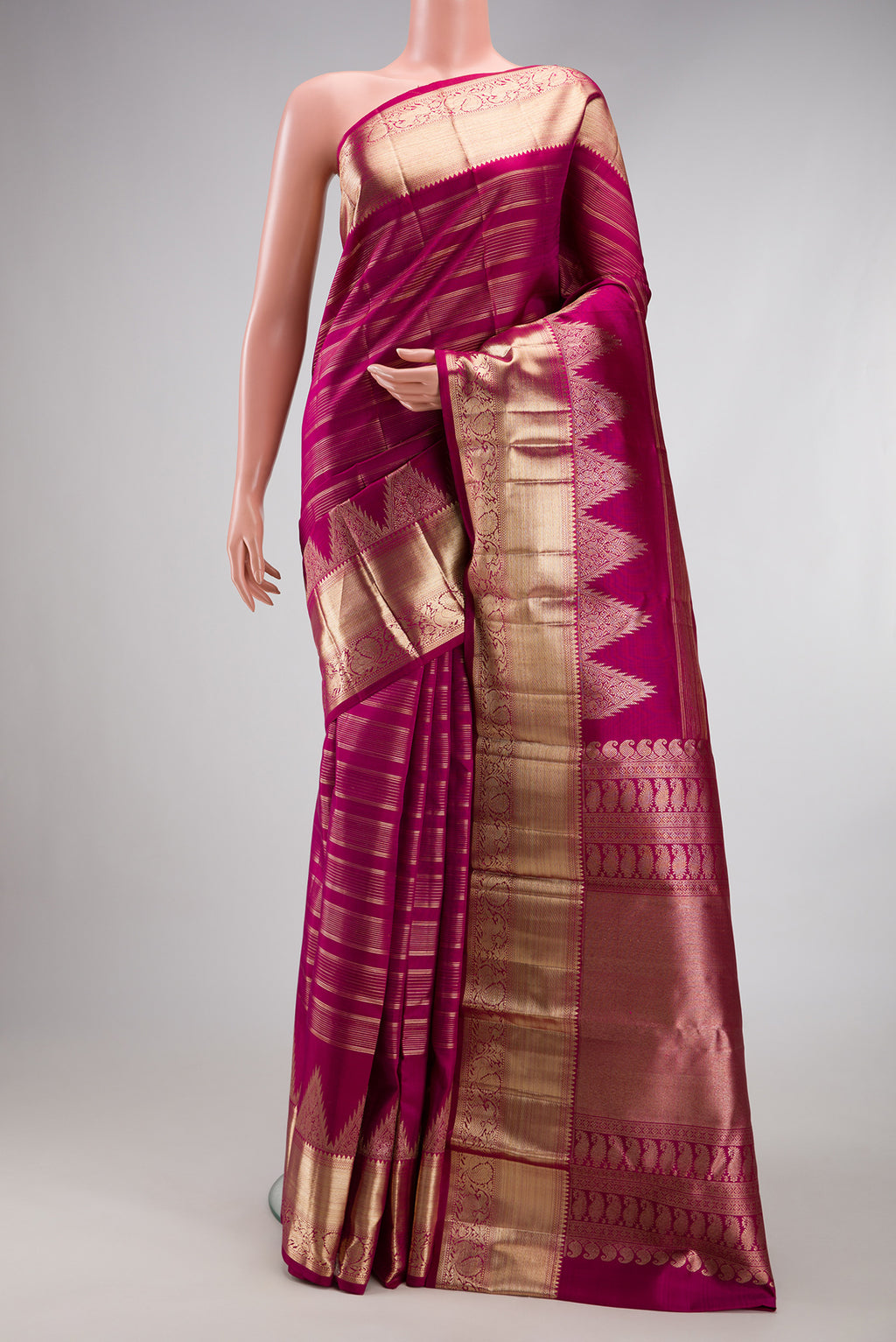 Magenta Kanchipuram Silk Saree with Stripes on the body and Fancy Border.  displayed on a mannequin