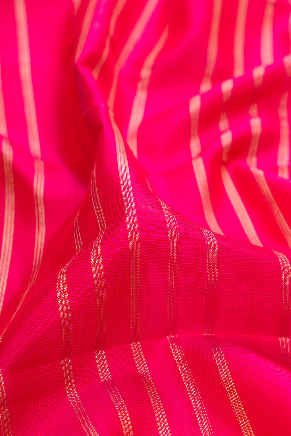 Close up of Dark Pink Dual Tone Kanchipuram Silk Saree with Stripes on the body and Fancy Border.  displaying folds