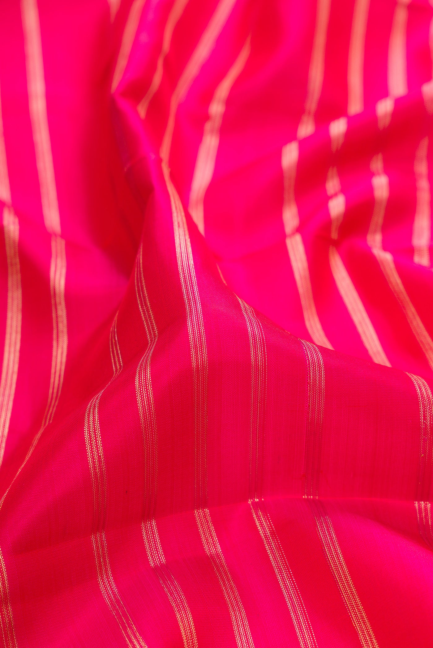 Close up of Dark Pink Dual Tone Kanchipuram Silk Saree with Stripes on the body and Fancy Border.  displaying folds