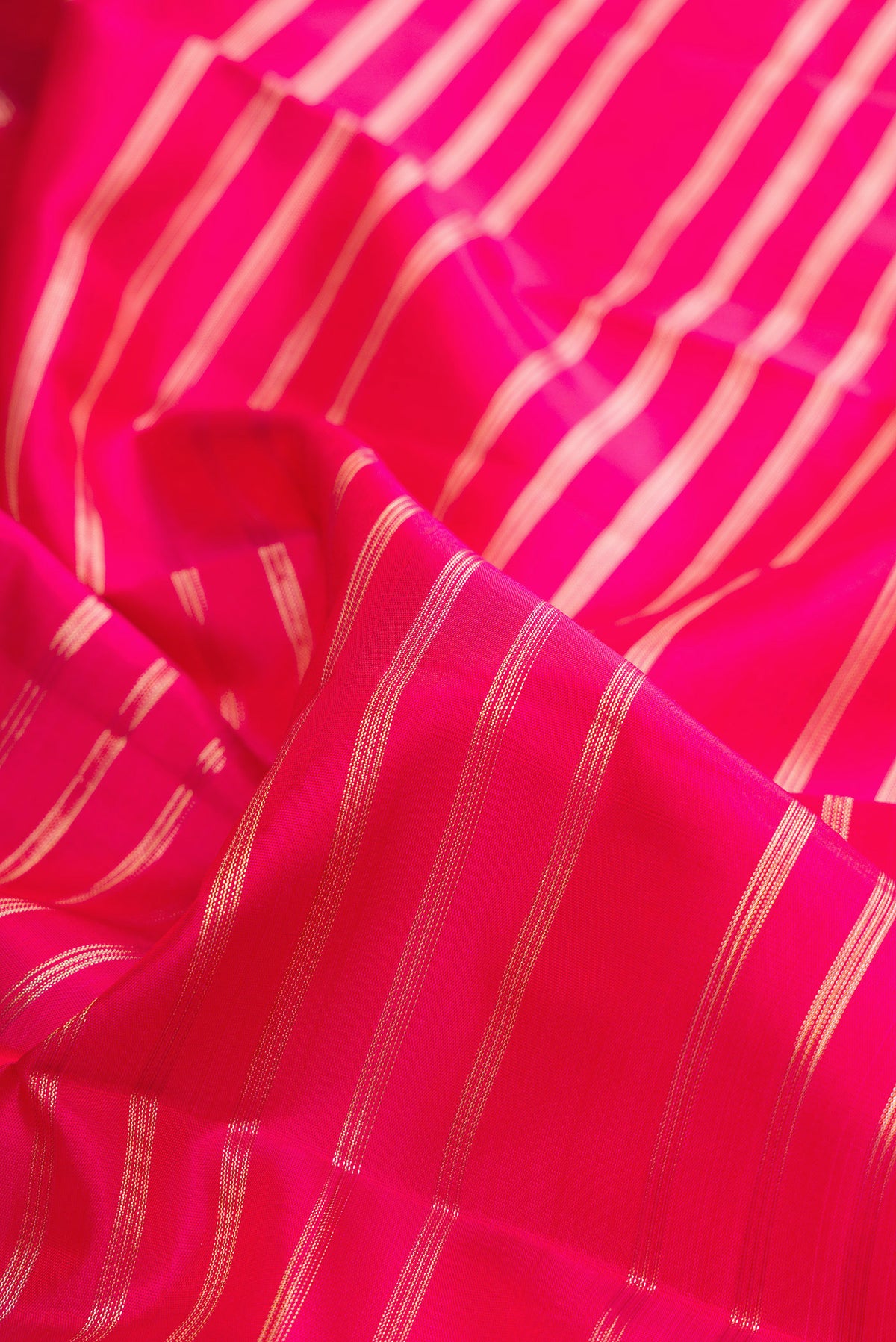 Close up of Pure Silk Pink Kanchipuram Saree with Stripes on the body and Fancy Border.  displaying folds