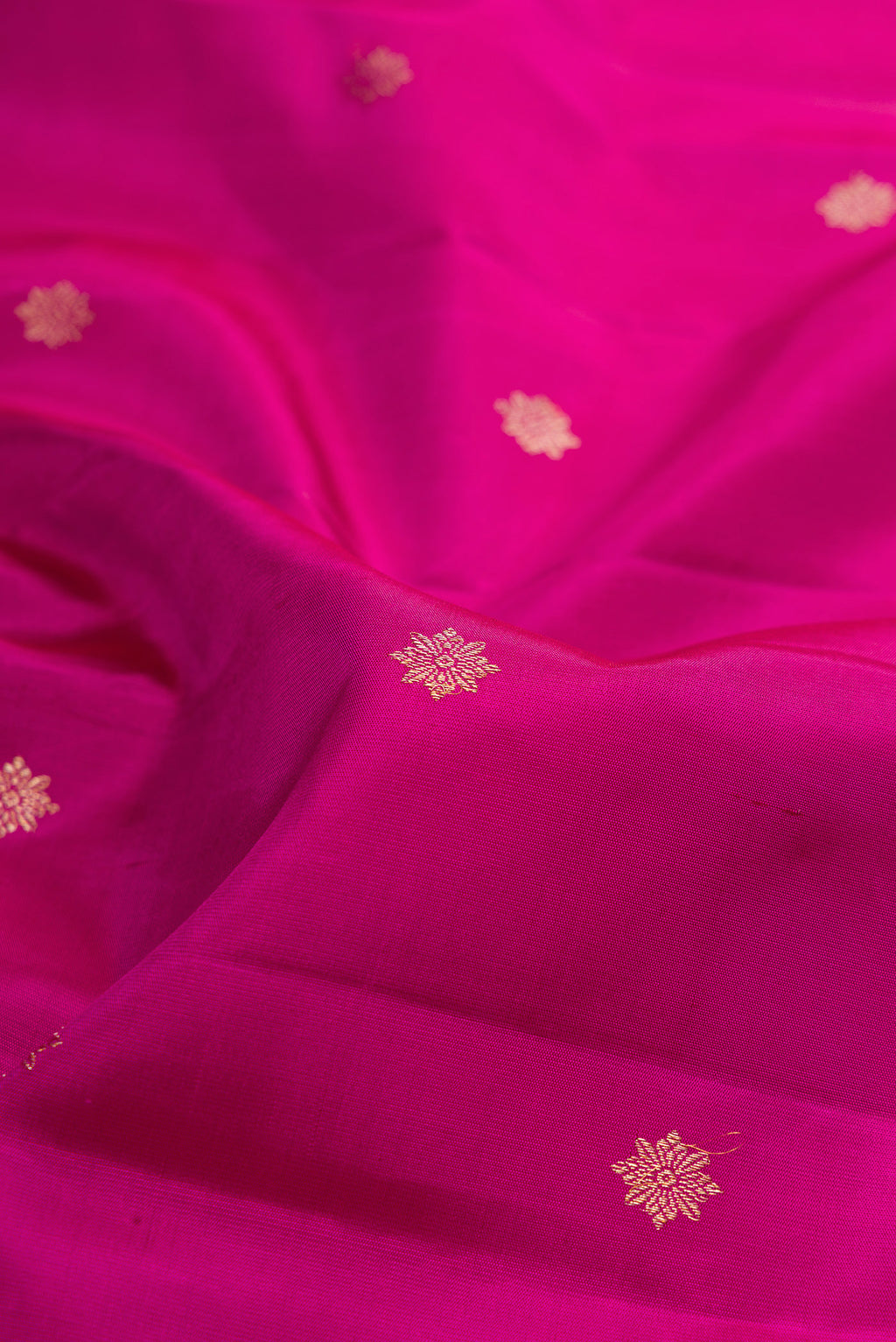 Close up of Pure Silk Magenta Kanjivaram Saree with Zari Butta on the body and Fancy Border.  displaying folds
