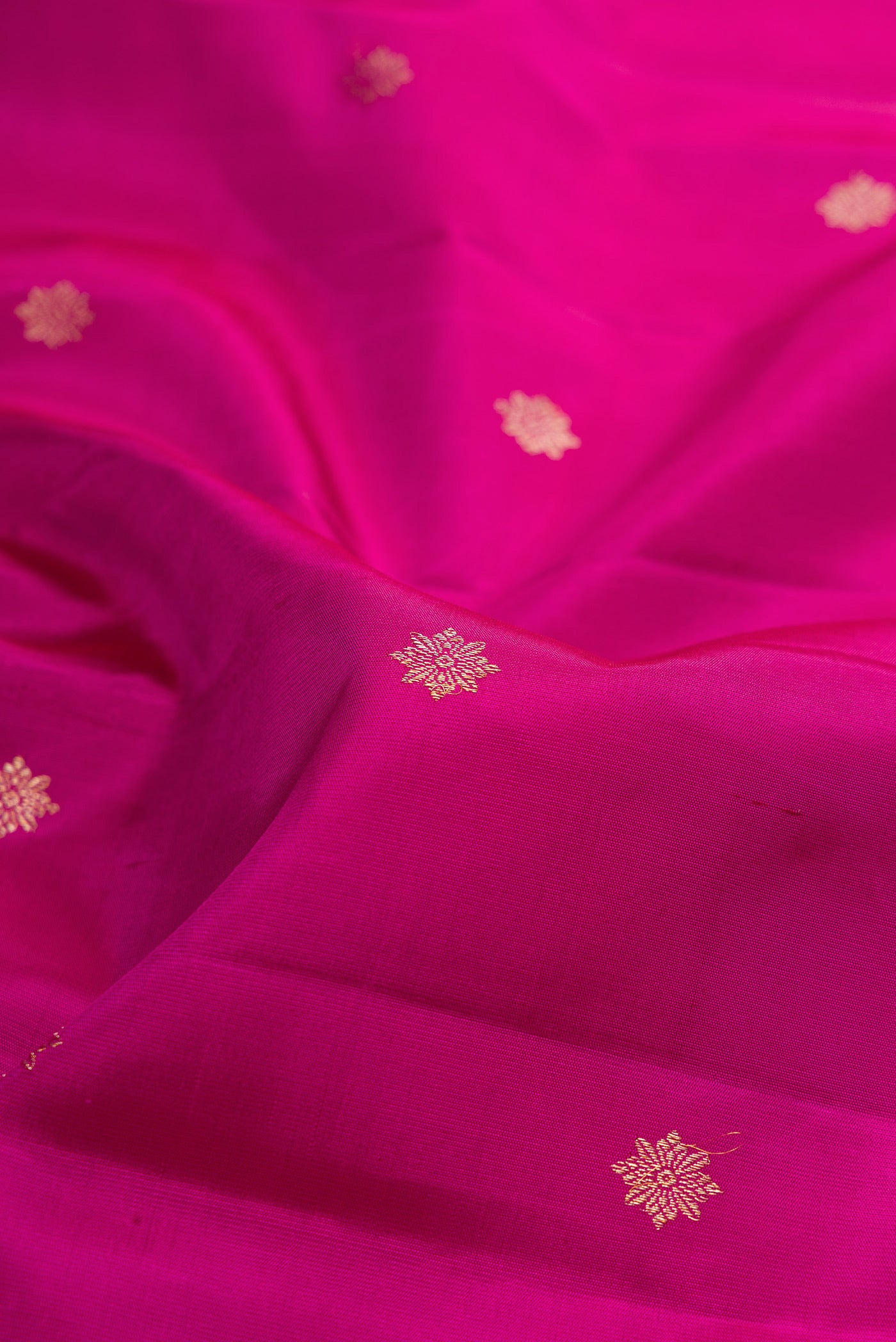 Close up of Pure Silk Magenta Kanjivaram Saree with Zari Butta on the body and Fancy Border.  displaying folds