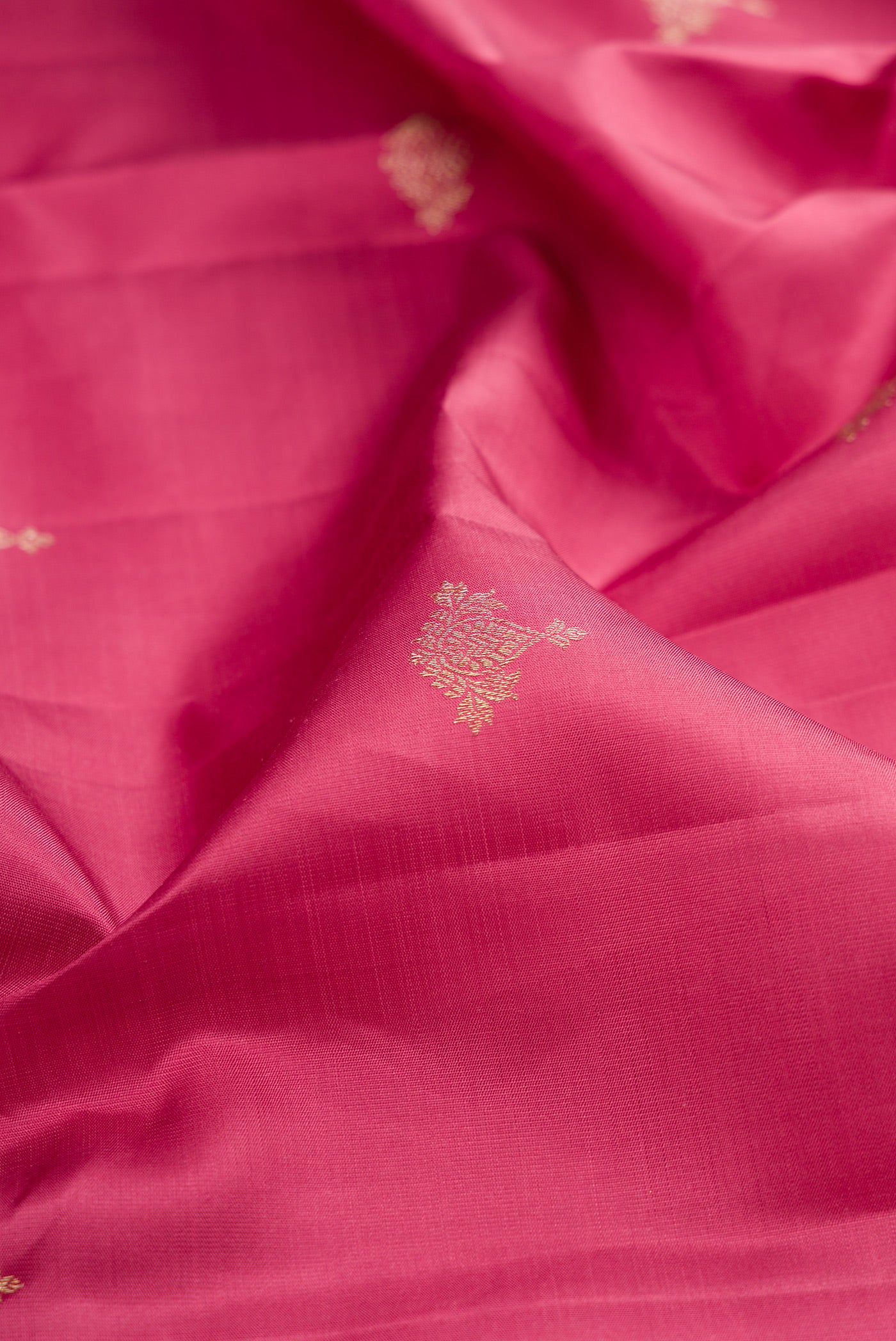 Close up of Pink Kanjivaram Silk Saree with Zari Butta on the body and Fancy Border.  displaying folds