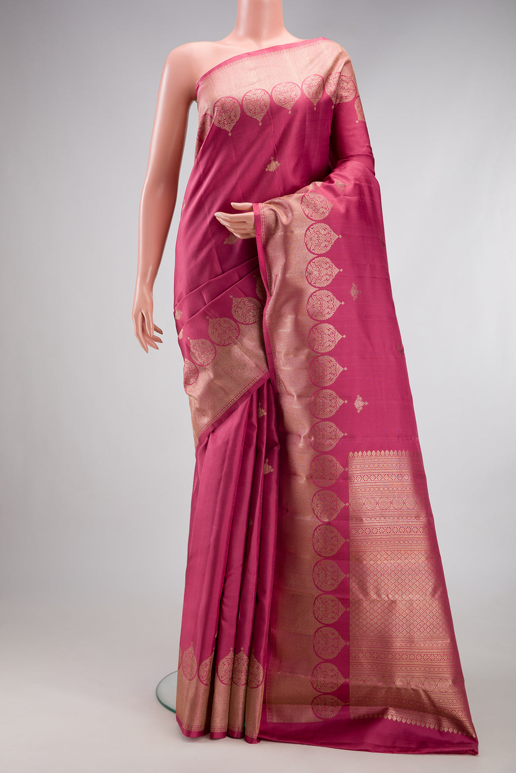 Pink Kanjivaram Silk Saree with Zari Butta on the body and Fancy Border.  displayed on a mannequin