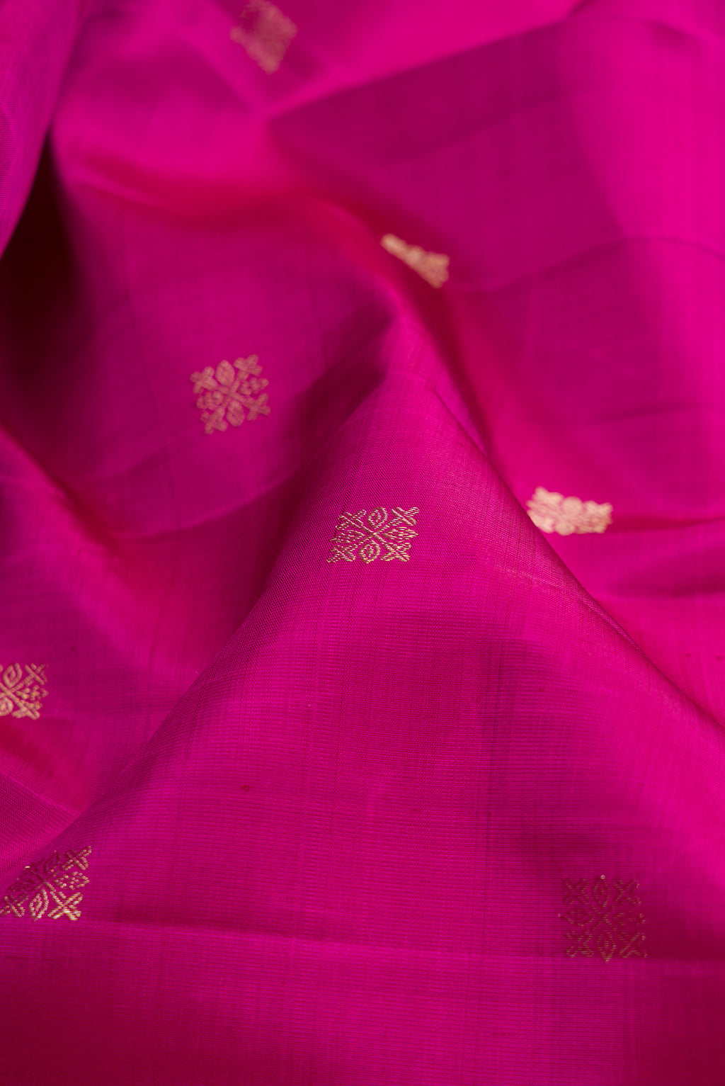 Close up of Magenta Kanjivaram Silk Saree with Zari Butta on the body and Fancy Border.  displaying folds