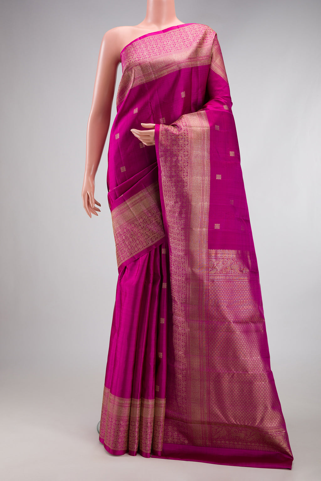 Magenta Kanjivaram Silk Saree with Zari Butta on the body and Fancy Border.  displayed on a mannequin