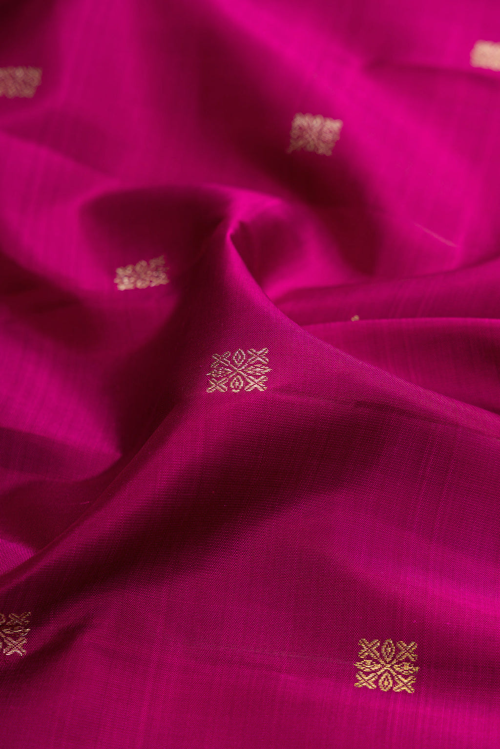 Close up of Magenta Kanjivaram Silk Saree with Zari Butta on the body and Fancy Border.  displaying folds