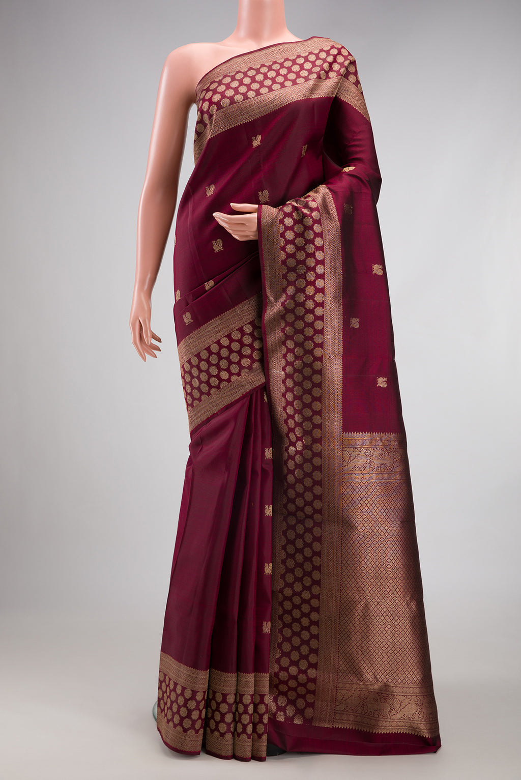 Maroon Kanjivaram Silk Saree with Zari Butta on the body and Fancy Border.  displayed on a mannequin