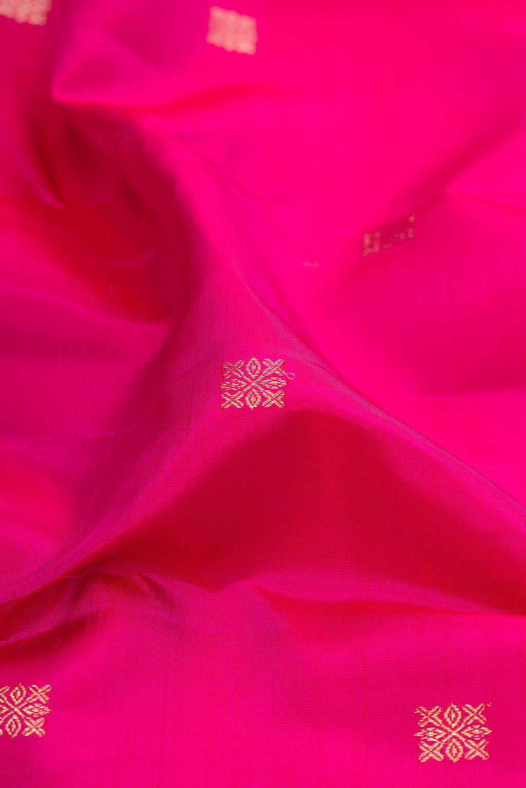 Close up of Dark Pink Kanjivaram Silk Saree with Zari Butta on the body and Fancy Border.  displaying folds