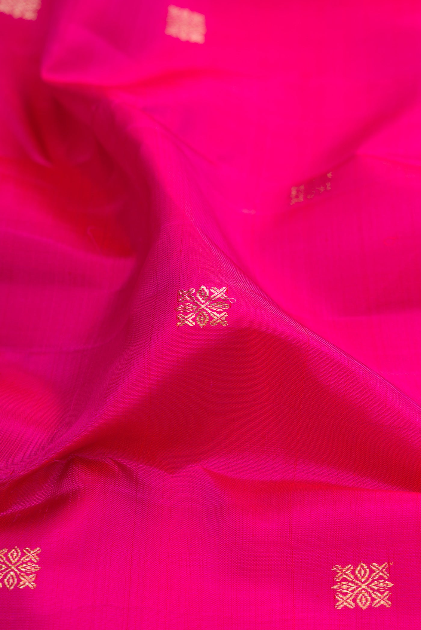 Close up of Dark Pink Kanjivaram Silk Saree with Zari Butta on the body and Fancy Border.  displaying folds