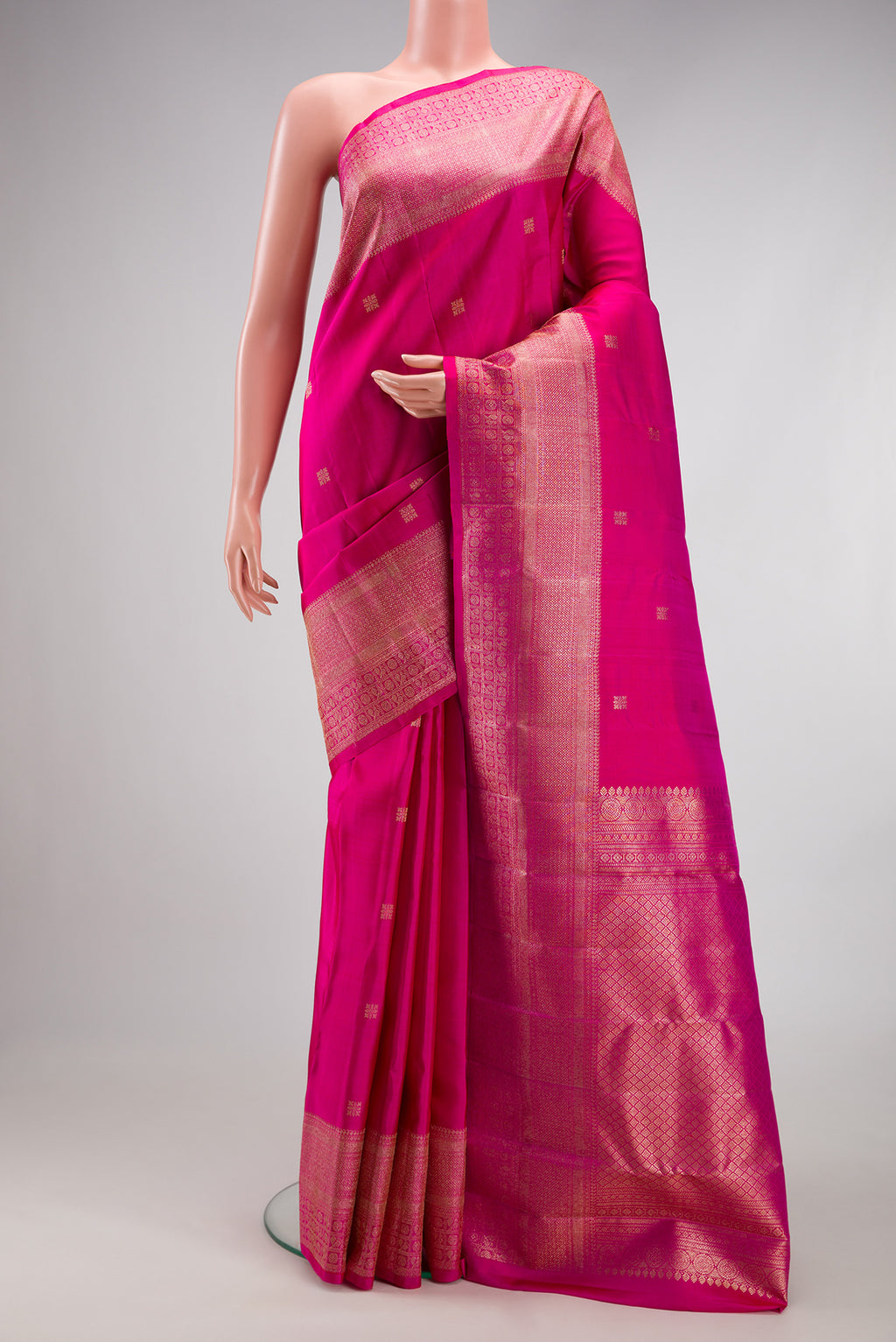 Dark Pink Kanjivaram Silk Saree with Zari Butta on the body and Fancy Border.  displayed on a mannequin