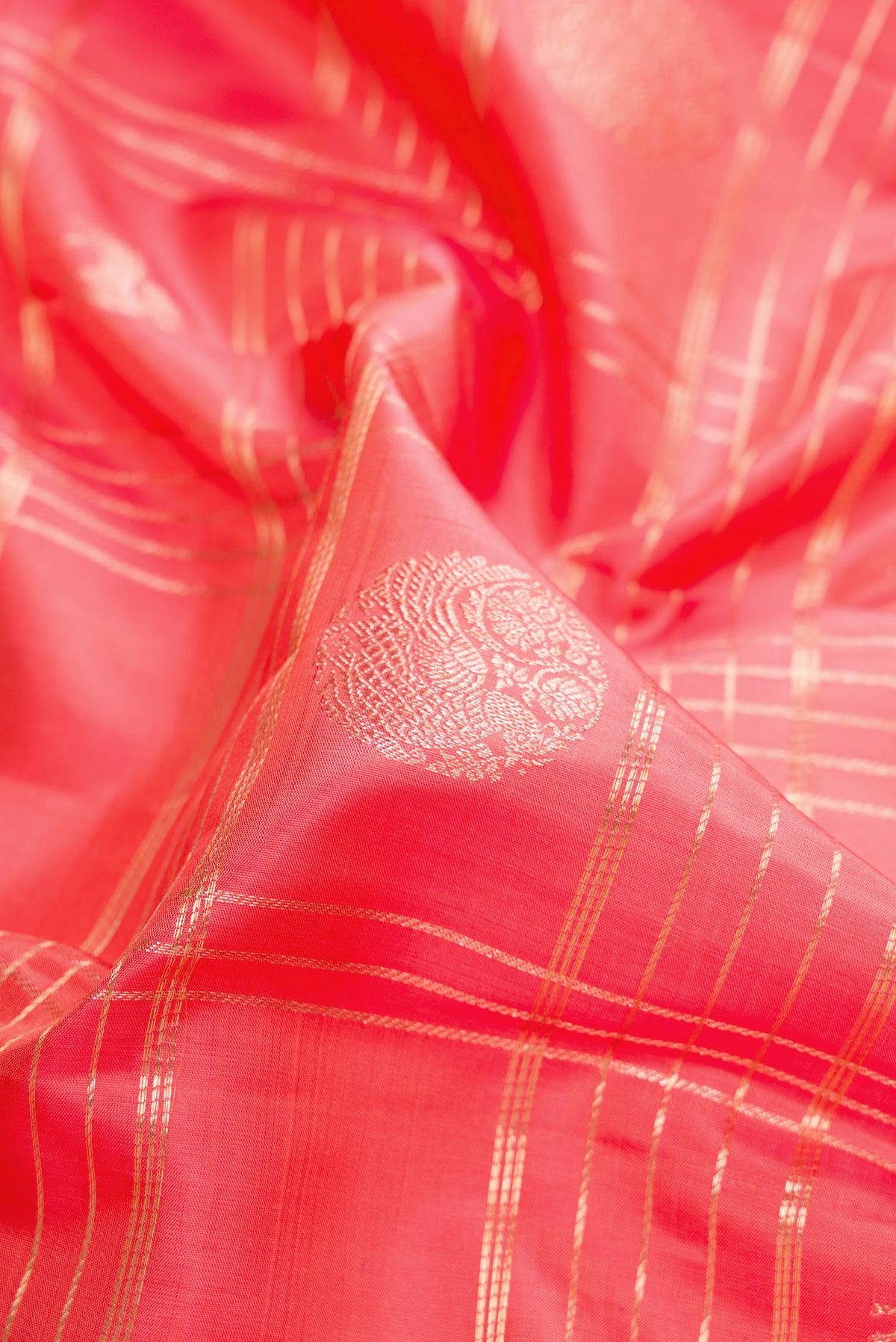Close up of Pure Silk Peach Kanchipuram Saree with Checked design on the body and Zari Border.  displaying folds