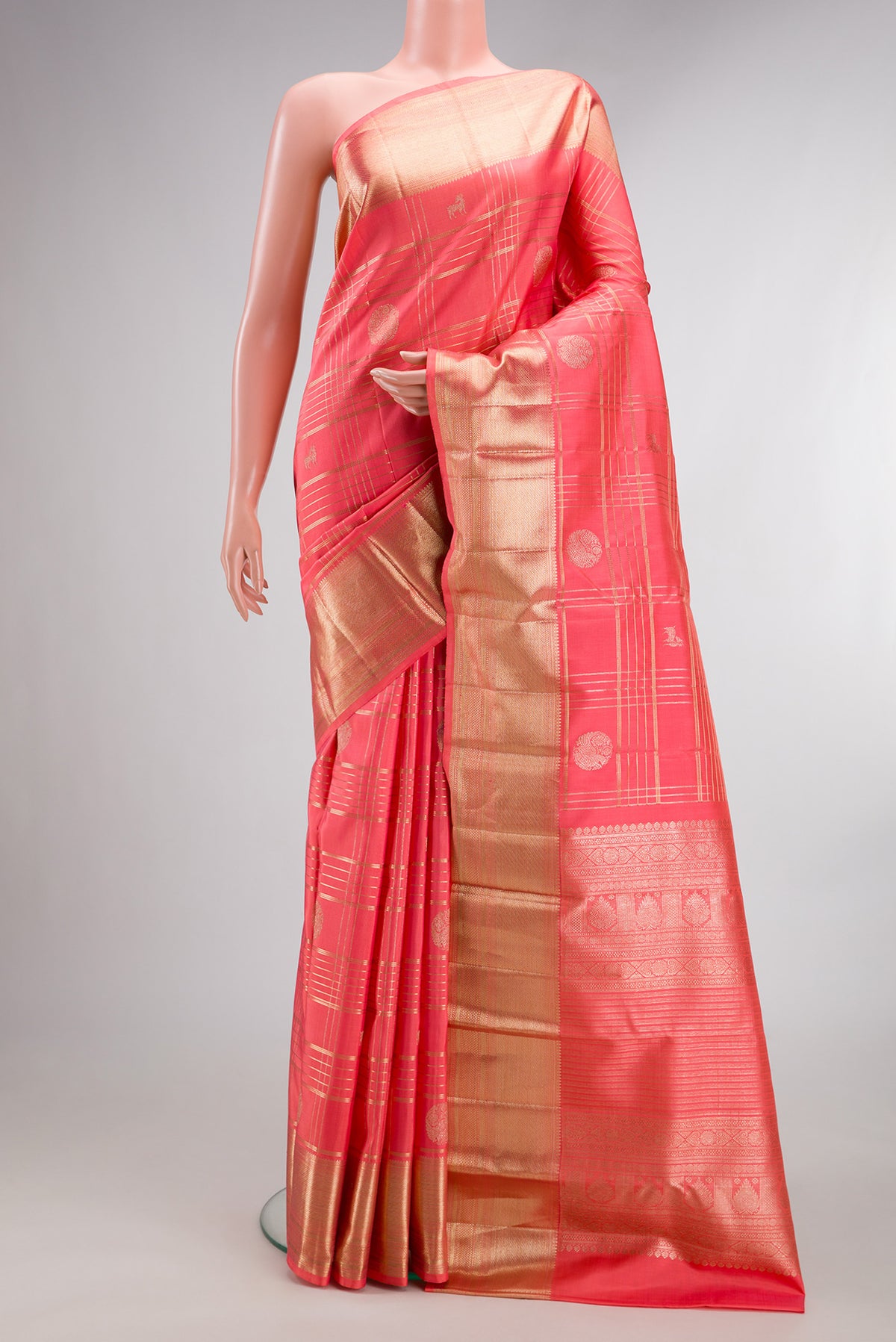 Pure Silk Peach Kanchipuram Saree with Checked design on the body and Zari Border.  displayed on a mannequin