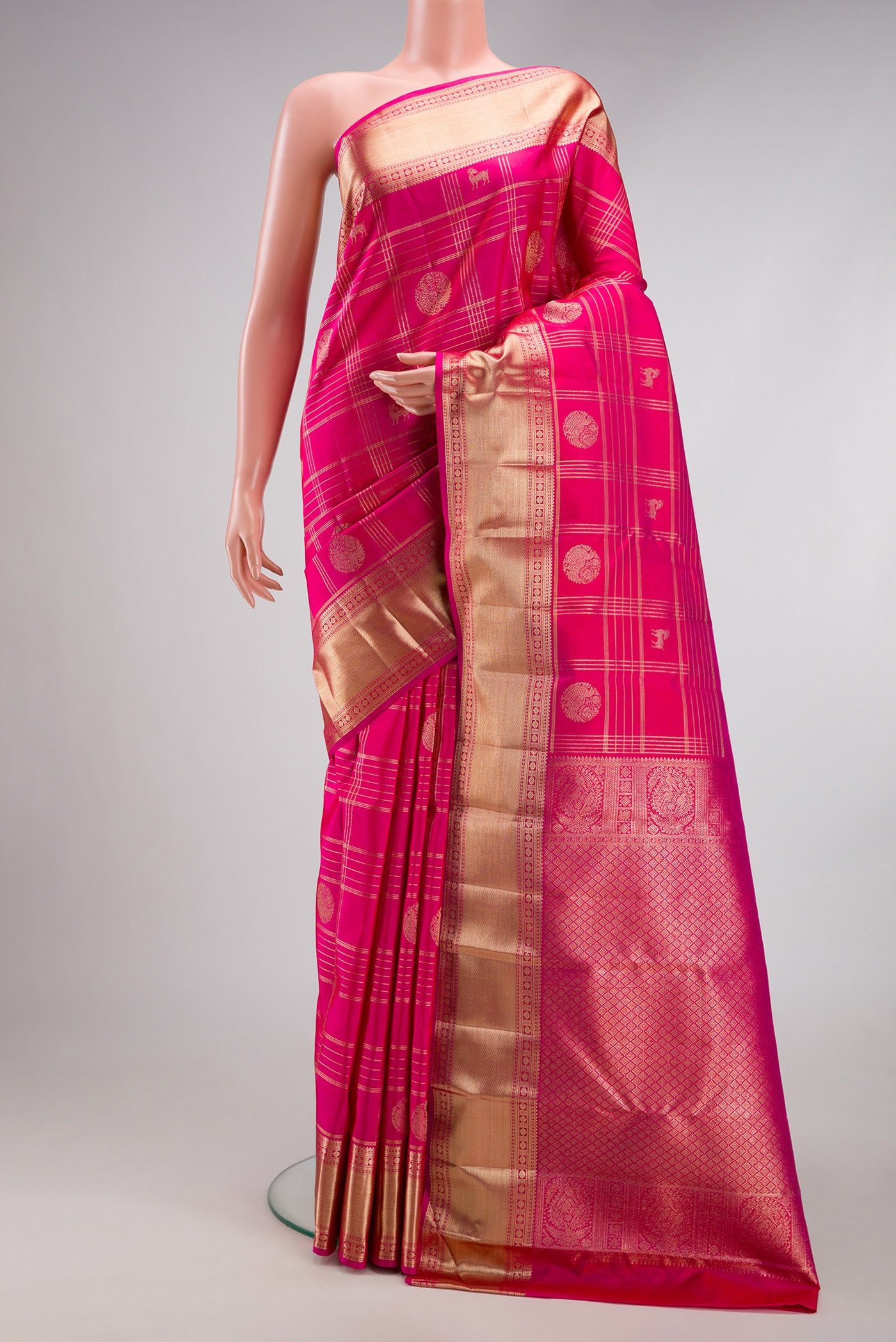 Rani Pink Kanchipuram Silk Saree with Checked design on the body and Zari Border.  displayed on a mannequin