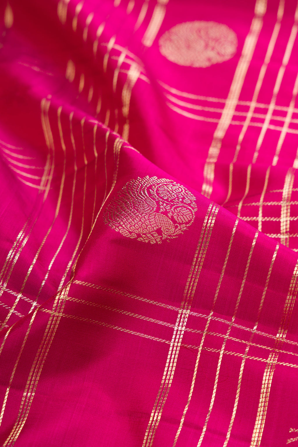 Close up of Magenta Kanchipuram Silk Saree with Checked design on the body and Zari Border.  displaying folds