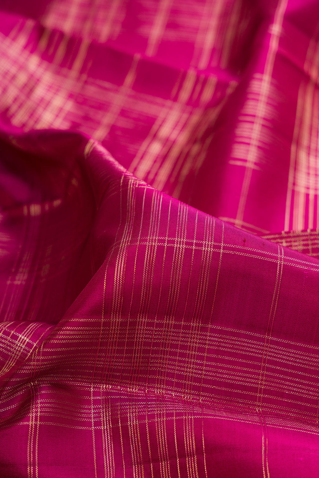 Close up of Pure Silk Dark Pink Kanchipuram Saree with Checked design on the body and Zari Border.  displaying folds