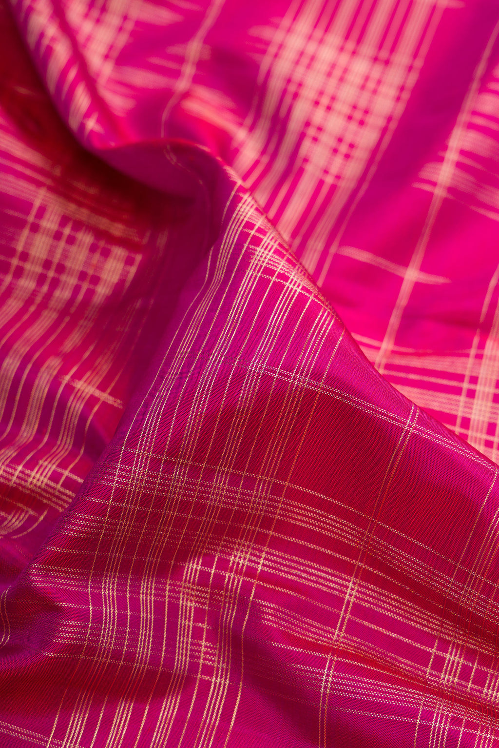 Close up of Pure Silk Dark Pink Kanchipuram Saree with Checked design on the body and Zari Border.  displaying folds