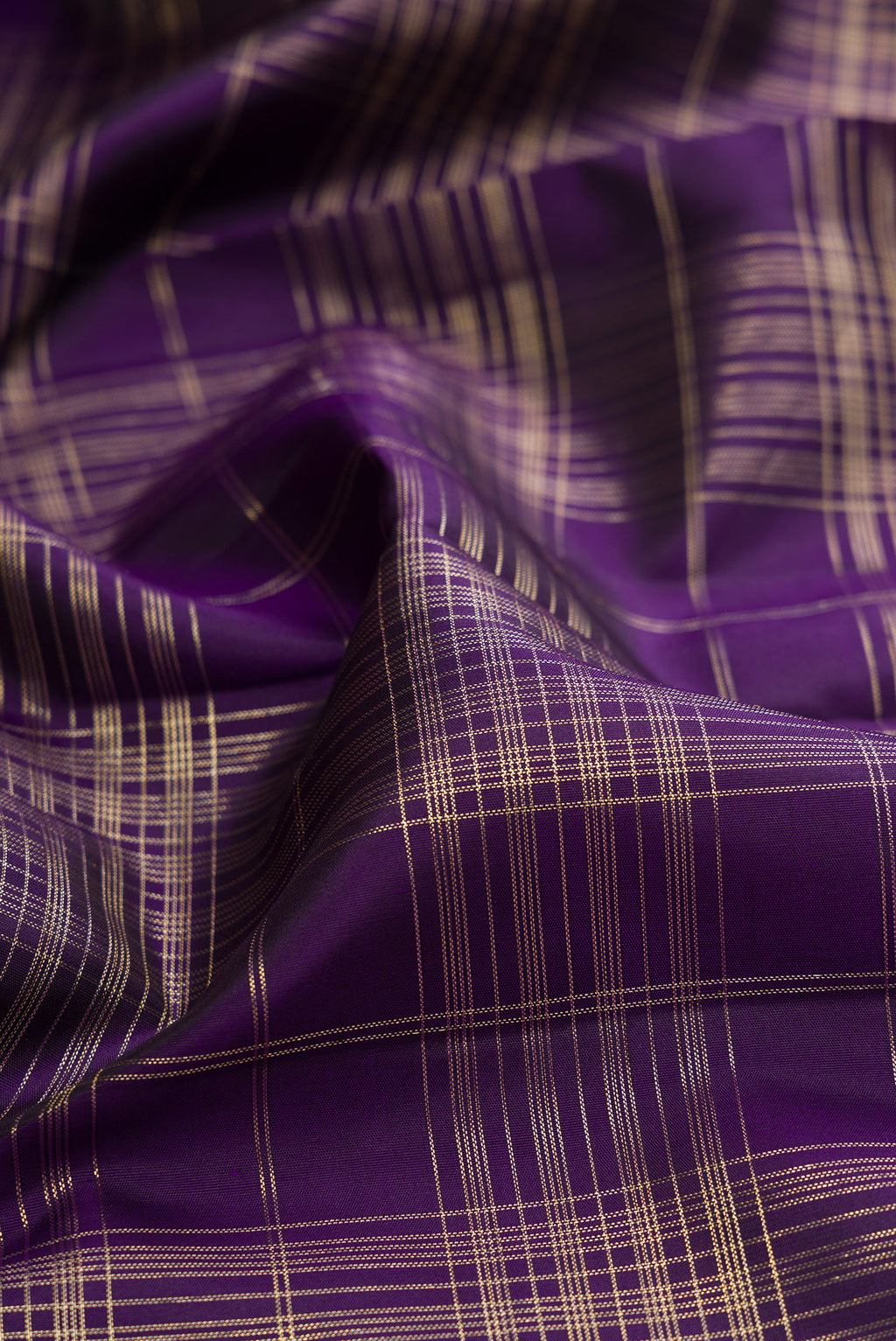 Close up of Violet Kanchipuram Silk Saree with Checked design on the body and Zari Border.  displaying folds
