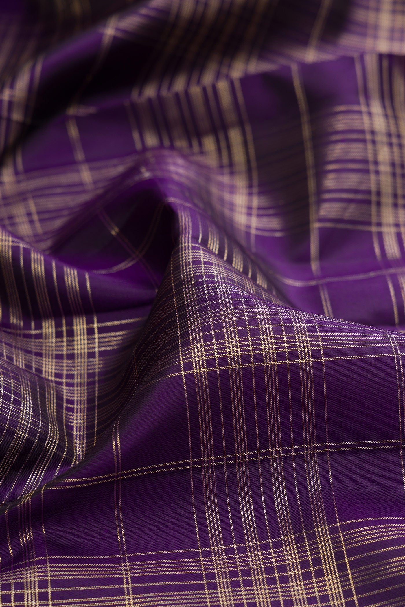Close up of Violet Kanchipuram Silk Saree with Checked design on the body and Zari Border.  displaying folds