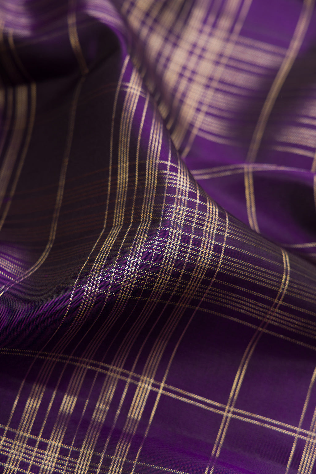 Close up of Violet Kanchipuram Silk Saree with Checked design on the body and Zari Border.  displaying folds