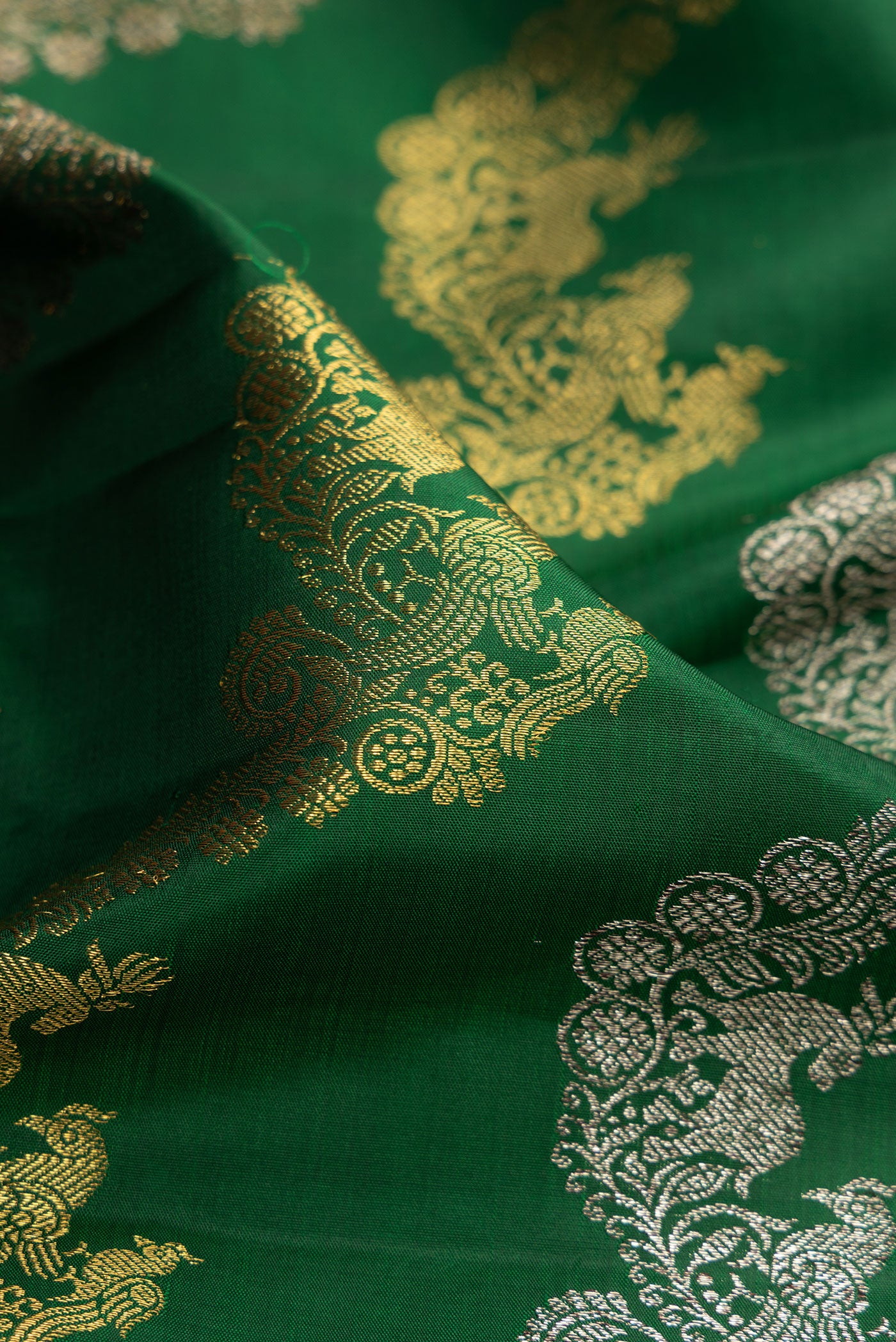 Close up of Green Kanchipuram Silk Saree with Zari Brocade on the body and Zari Border.  displaying folds