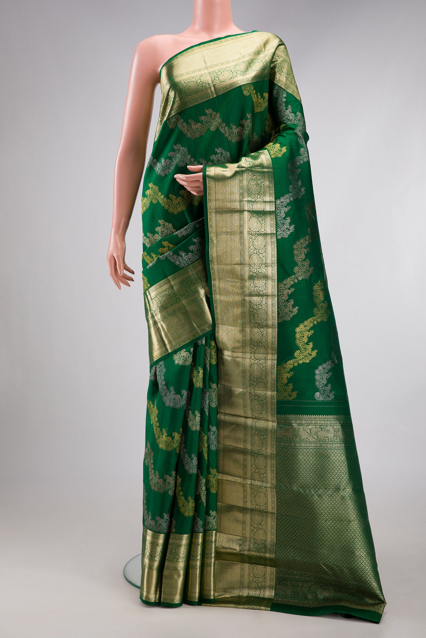 Green Kanchipuram Silk Saree with Zari Brocade on the body and Zari Border.  displayed on a mannequin