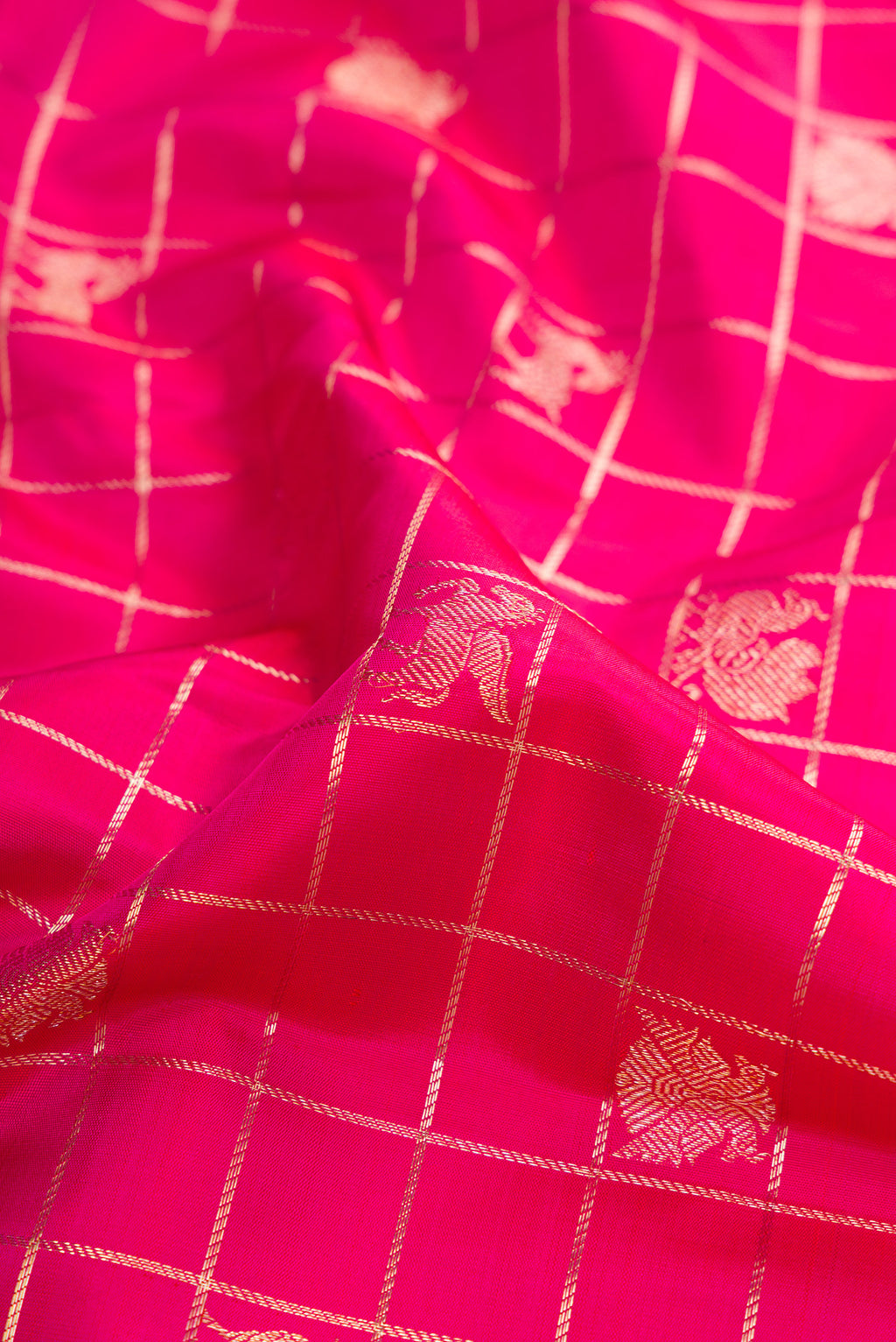 Close up of Dark Pink Kanchipuram Silk Saree with Checked design on the body and Zari Border.  displaying folds